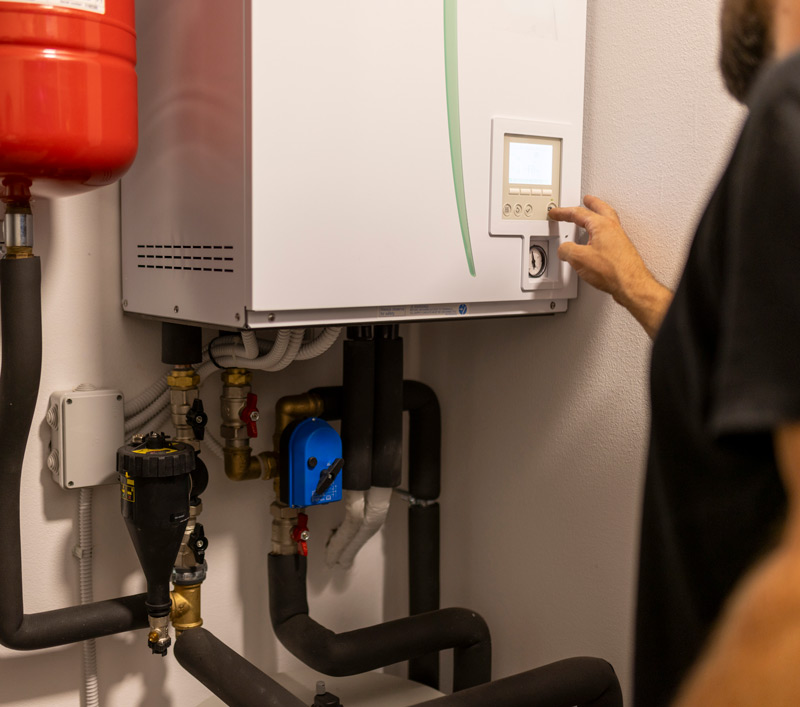 Man enter setting into an electric heat pump