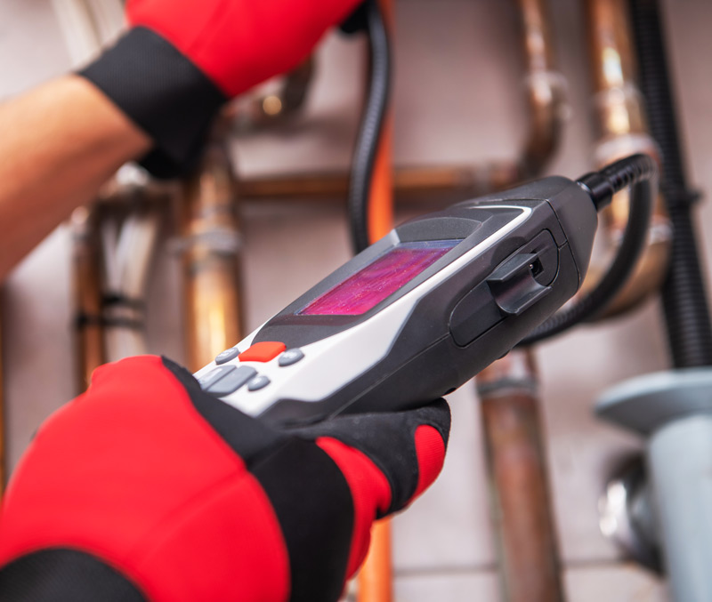 Technician Uses Advanced Device to Inspect Natural Gas Systems at Facility